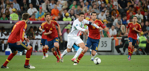 Cristiano Ronaldo behind enemy lines, as he tries to get away from Gerard Piqué, Xabi Alonso and Xabi, in Portugal vs Spain, at the EURO 2012