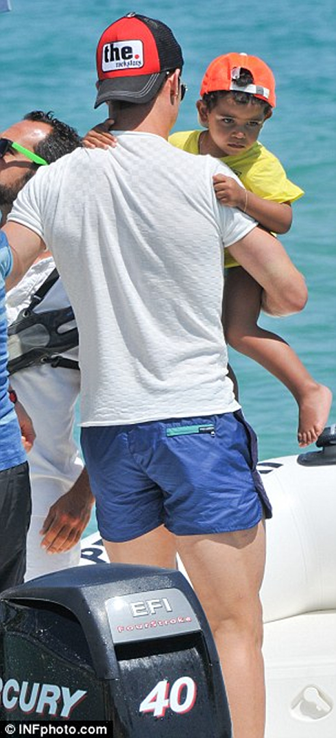 Cristiano Ronaldo carrying his son, Cristiano Ronaldo Junior, with his right arm, in 2012