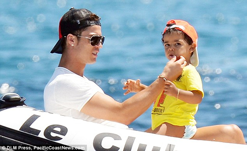 Cristiano Ronaldo cleaning Cristianito mouth, as he watches out for his son, Junior, in 2012