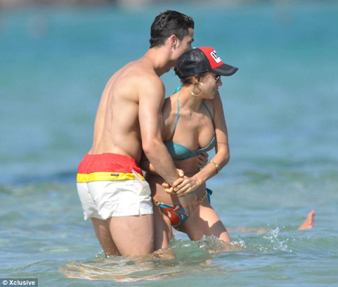 Cristiano Ronaldo grabbing Irina Shayk from her waist, while both play on the water, in 2012