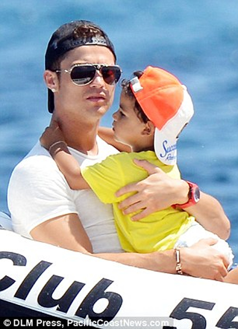 Cristiano Ronaldo holding his son with both hands, as they go for a ride on a boat in 2012