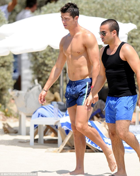 Cristiano Ronaldo walking with a friend on the beach, and showing all his toned and big muscles, in 2012