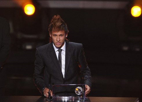 Neymar dressed in a suit and granting a speech at an awards ceremony gala