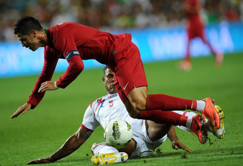 Cristiano Ronaldo being tackled in a game for Portugal, in 2012
