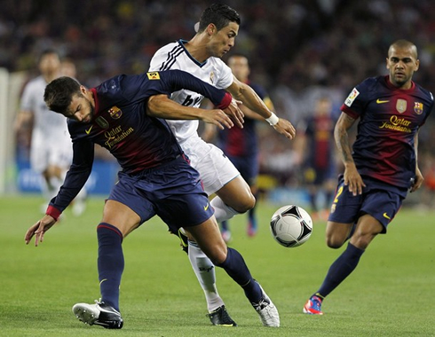Cristiano Ronaldo trying to recover the ball from Gerard Piqué and Daniel Alves, in Barça vs Real Madrid in 2012
