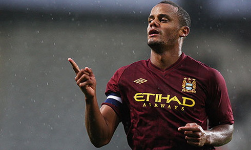 Vincent Kompany wearing the new red Manchester City jersey, kit and uniform, in 2012-2013