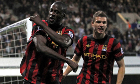 Yaya Touré celebrating Manchester City goal, with a controversial gesture, while Dzeko appears from behind, in 2012-2013