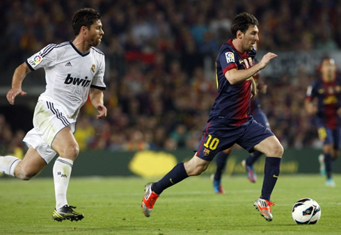 Lionel Messi running away from Xabi Alonso in Barcelona vs Real Madrid for La Liga 2012-2013