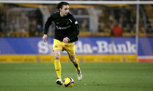 Neven Subotić running with the ball in a Borussia Dortmund black jersey, shirt, kit and uniform