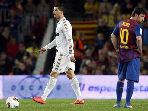 Cristiano Ronaldo walking away as Lionel Messi spits to the ground