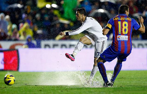 Cristiano Ronaldo playing in a wet football pitch, in Levante vs Real Madrid and with Sergio Ballesteros marking him, in 2012-2013