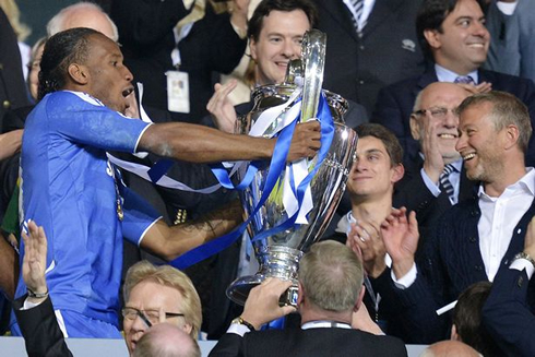 Didier Drogba handing the UEFA Champions League trophy to Roman Abramovich, in 2012