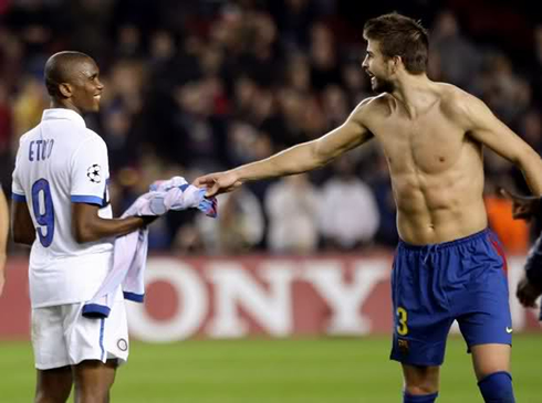 Gerard Piqué naked, showing his muscles and six pack abs, as he hands his shirt to Samuel Etoo