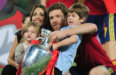 Xabi Alonso family photo, with his wife and two sons holding the World Cup trophy