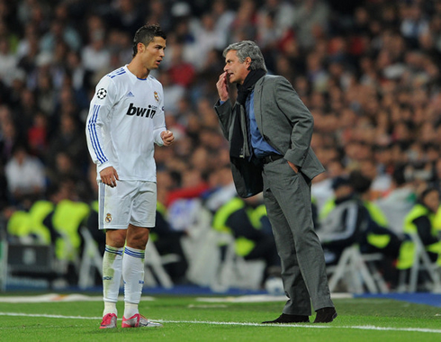 Cristiano Ronaldo hearing José Mourinho, as he talks with him during a game