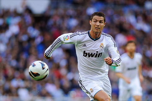 Cristiano Ronaldo running after a soccer ball, in a Real Madrid game in 2012-2013