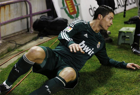 Cristiano Ronaldo in a green Real Madrid jersey, after being pushed outside the pitch, in a match for La Liga in 2012-2013