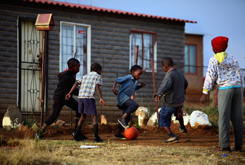 Kids playing football in a poor under-developped country in Africa