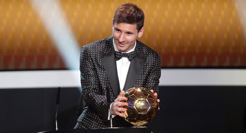 Lionel Messi grabbing the FIFA Balon d'Or 2012 trophy on his weird suit picked for the event