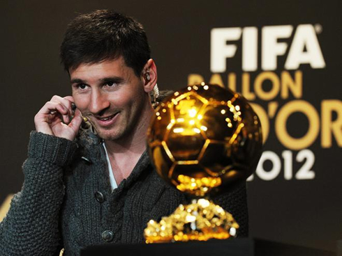 Lionel Messi smiling and adjusting the headphones, at the FIFA Balon d'Or 2012 press conference
