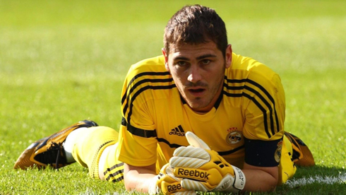 Iker Casillas lied on the ground, in a yellow goalkeeper jersey and kit for Real Madrid