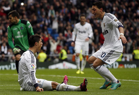 Cristiano Ronaldo and Mesut Ozil about to hug each other on the ground, in Real Madrid vs Getafe in 2013