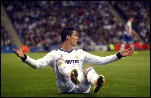 Cristiano Ronaldo opening his arms while seated on the grass, in La Liga 2013