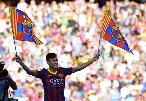 Neymar at the Camp Nou, on his presentation day, holding two Barcelona flags