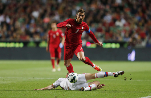 Cristiano Ronaldo jumping over a Russian opponent who was sliding on the ground, in FIFA's WC 2014 qualifiers