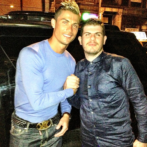 Cristiano Ronaldo smiling to the camera, with a friend next to him