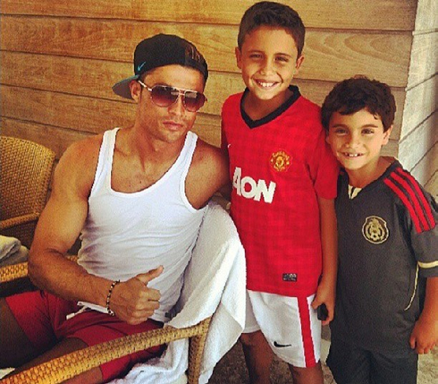 Cristiano Ronaldo taking a photo with two boys wearing Manchester United and Mexico jerseys