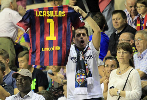 Fan holding up a Barcelona jersey and shirt, with Iker Casillas name printed on it