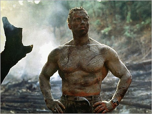 Arnold Schwarzenegger covered in mud, during Predator shooting
