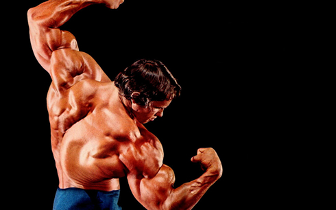 Arnold Schwarzenegger doing a body builder pose in a contest