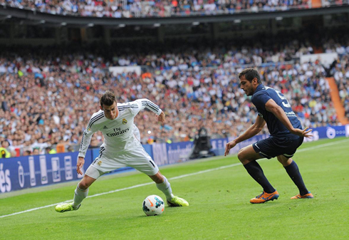 Cristiano Ronaldo trying to dribble a defender, in Real Madrid vs Malaga