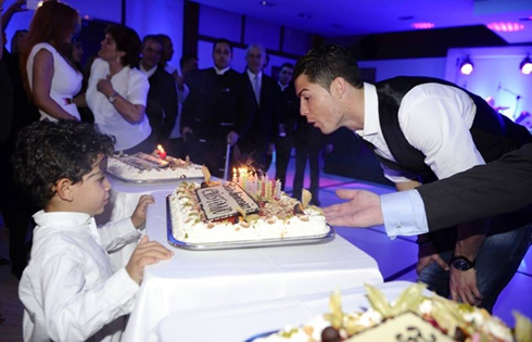 Cristiano Ronaldo and his son, blowing the candles of his birthday cake