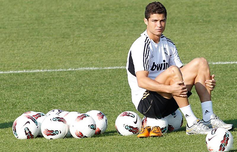 Cristiano Ronaldo stitting on the footballs, during a training session