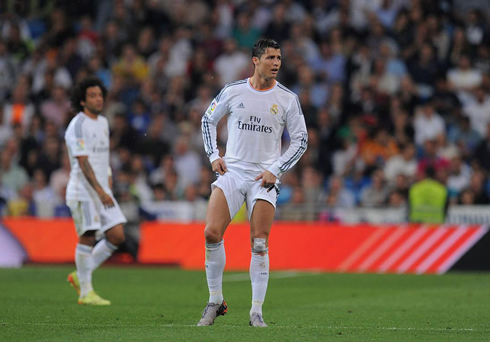 Cristiano Ronaldo showing off his thighs and leg muscles, as he pulls his shorts up