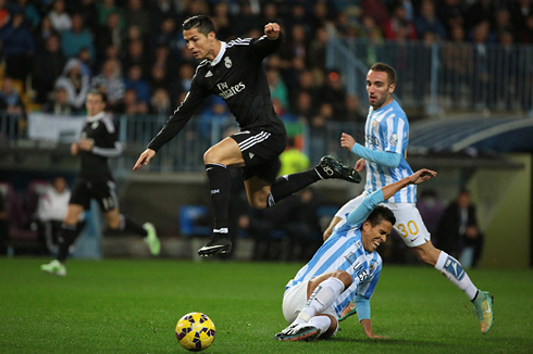 Cristiano Ronaldo jumping over a defender sliding on the ground