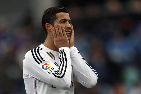 Cristiano Ronaldo reacts by holding his own face