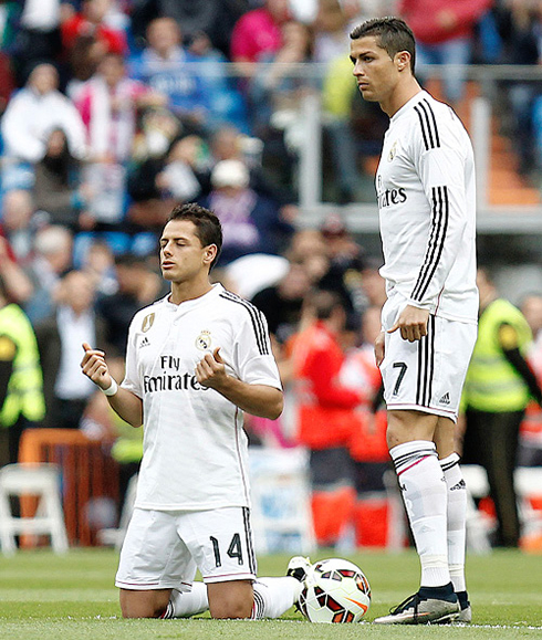 Chicharito praying on his knees, next to Cristiano Ronaldo