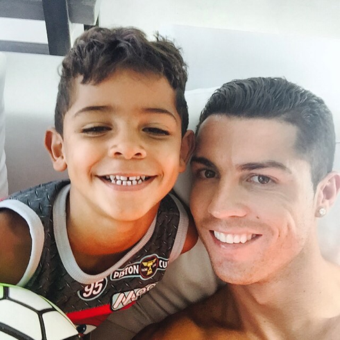 Cristiano Ronaldo and his son smiling to the camera