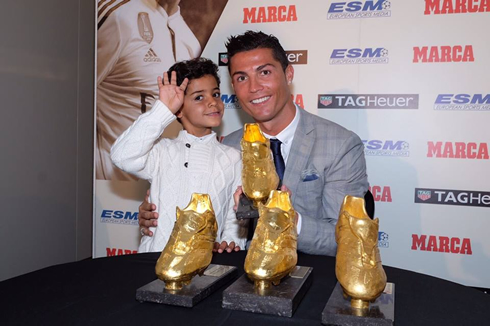 Cristiano Ronaldo and his son, next to the 4 Golden Shoes