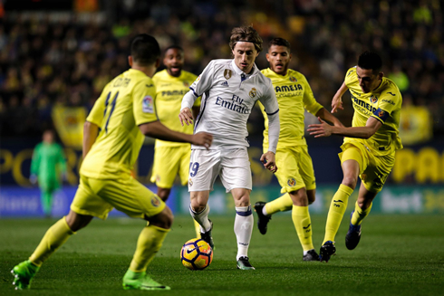 Luka Modric surrounded by Villarreal players in a game for Real Madrid