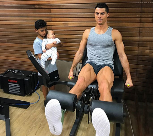 Cristiano Ronaldo training his legs in home gym next to his son
