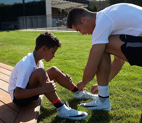 Cristiano Ronaldo helping his son Cristiano Jr tying his boots