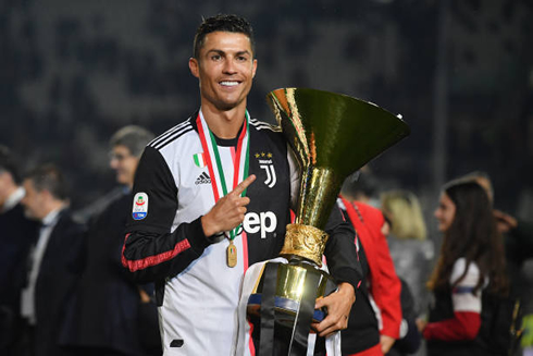 Cristiano Ronaldo taking a picture with the Serie A trophy in 2019