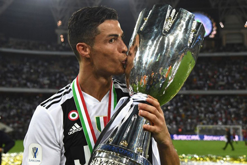 Cristiano Ronaldo holding and kissing a trophy won for Juventus