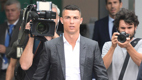 Cristiano Ronaldo walking off the courts with journalists behind him