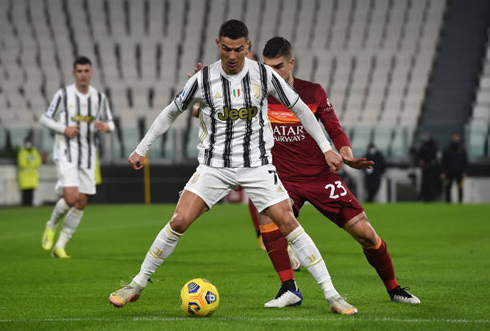 Cristiano Ronaldo guarding the ball from a Roma opponent